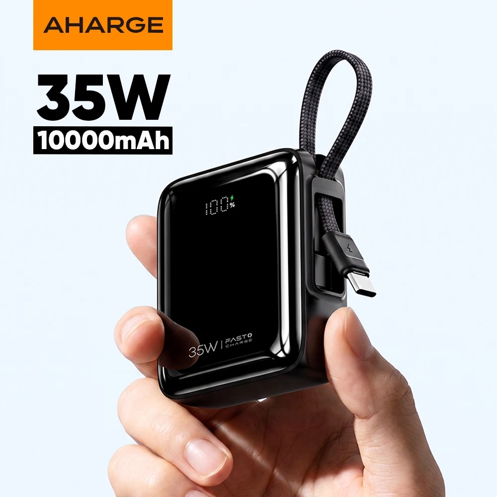 מטען נייד מיני AHARGE בצבע שחור עם כבל USB-C מובנה בצורת רצועה ומסך דיגיטלי, מוחזק ביד
